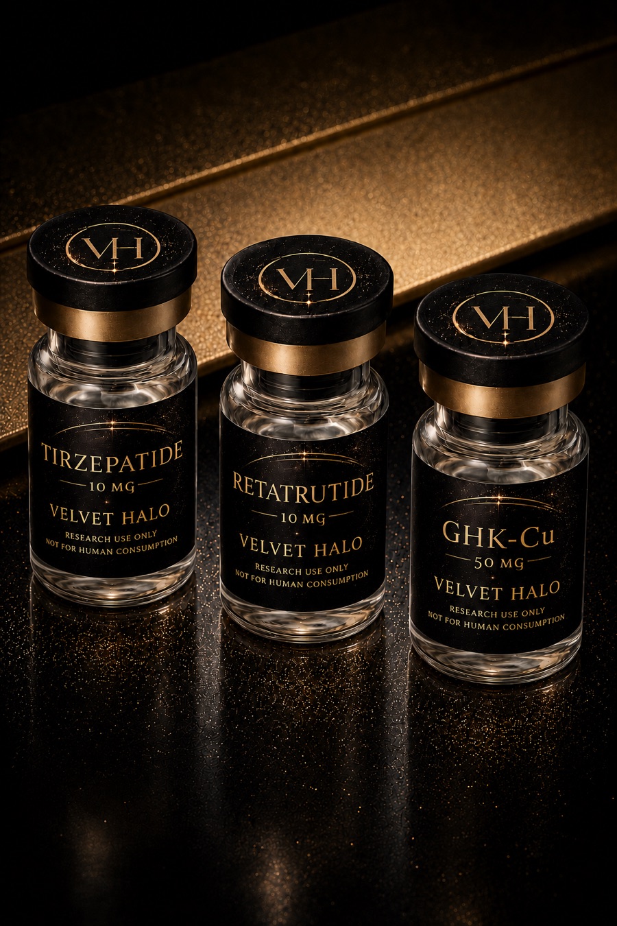 Three Velvet Halo research peptide vials with black and gold labels on a dark surface